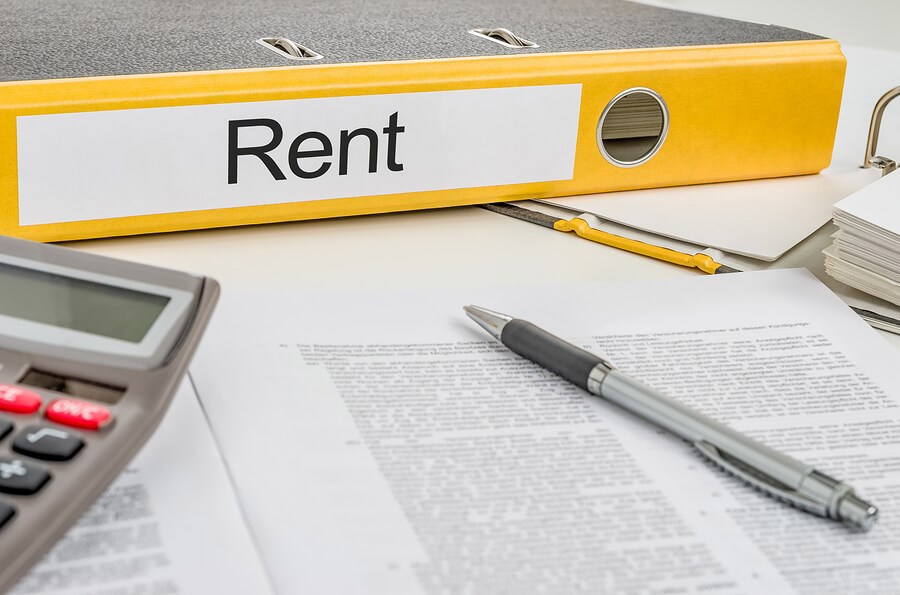 Items on a desk including a folder marked Rent